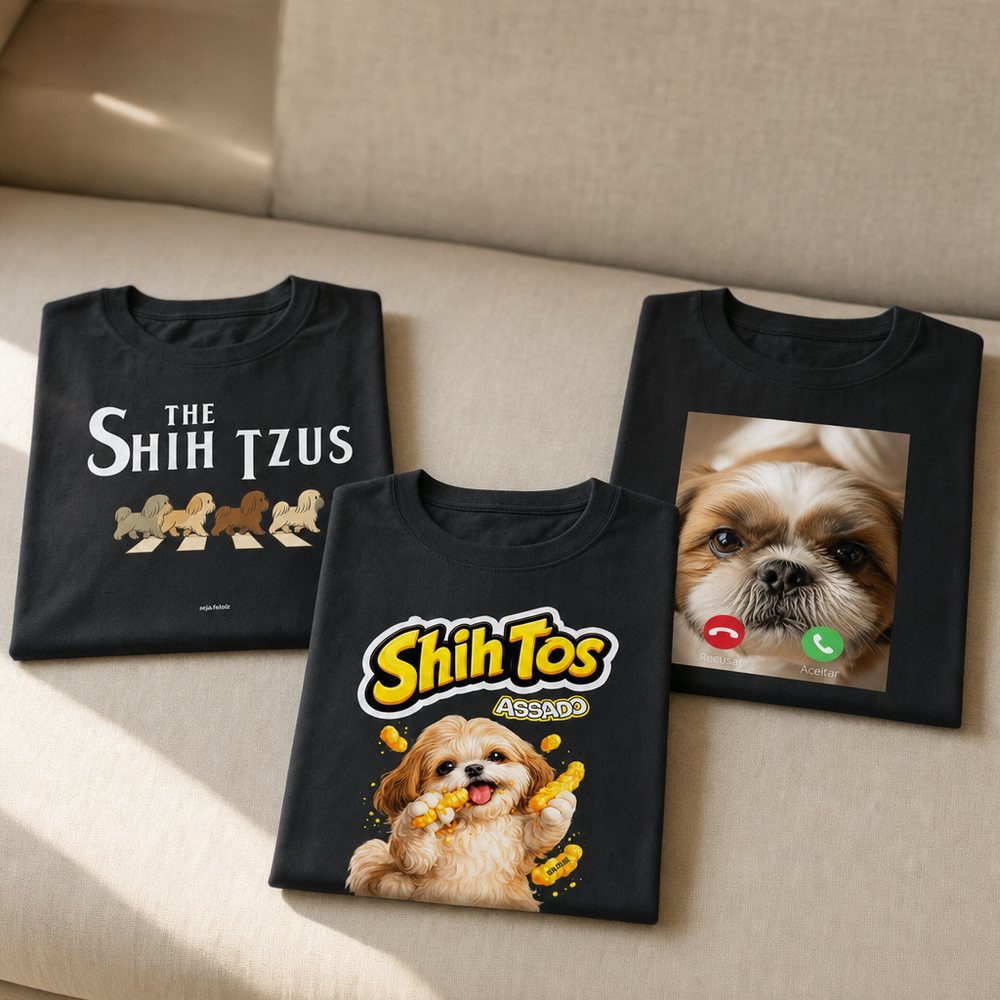 Route 1 rough: three folded black Shih Tzu t-shirts on the seat of a sand-coloured linen sofa, soft daylight, blurred backrest above.